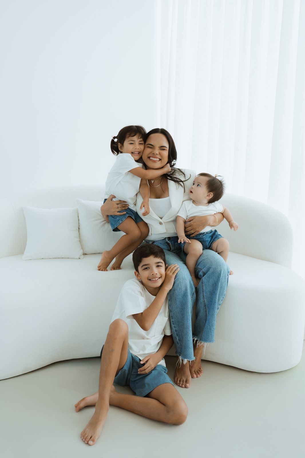 Fotografia espontânea da mãe com os três filhos, representando proximidade e conexão familiar.
